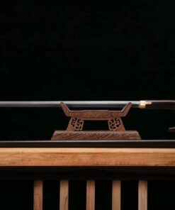 A walking cane sword displayed on a wooden sword-stand, with its scabbard-stick below on the floor.
