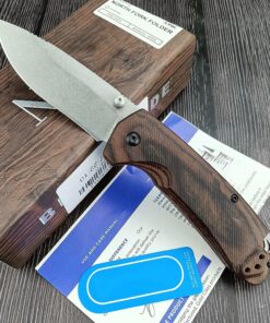 A folding bushcraft knife lying against its knife box.