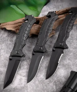 Three seat belt cutter and window breaker knives resting against a small log.